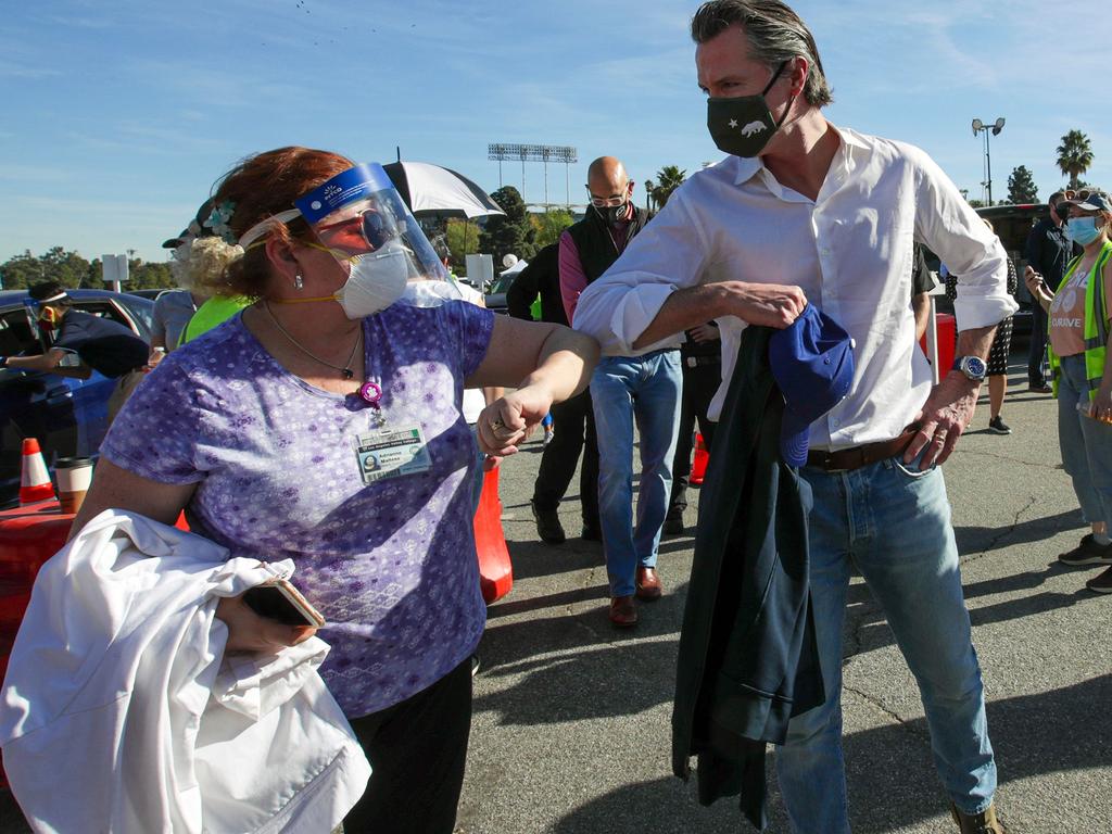 California Governor Gavin Newsom, right, is greeted by a healthcare worker at the launch of a mass COVID-19 vaccination site at Dodger Stadium in Los Angeles. Picture: AFP