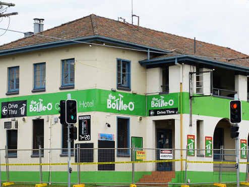 END OF AN ERA: Construction fencing is erected at The One Mile Hotel and the pub signs are removed from the facade and the roof. Picture: Rob Williams