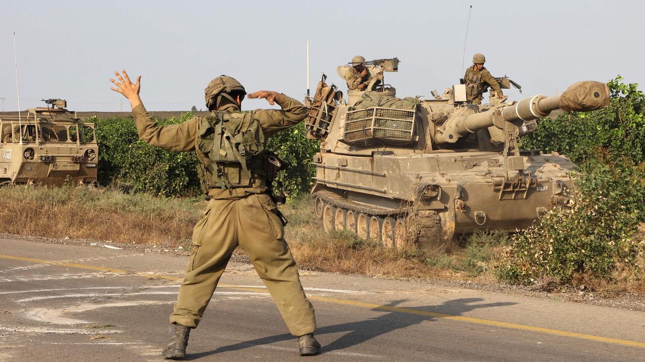 An Israeli soldier directs a military vehicle near the southern city of Ashkelon on October 8, 2023. Picture: AFP