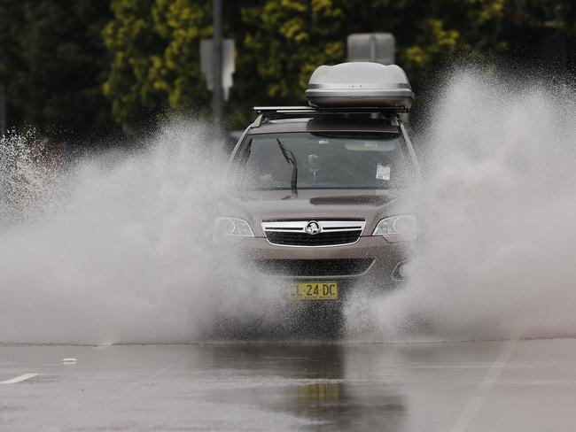 Cars on Pittwater Rd drive through flooding  Photos by Chris Pavlich for The Daily Telegraph