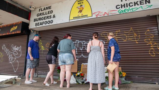 Community members come to lay flowers at the hamburger shop. Picture: Thomas Lisson