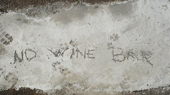 Someone opposed to a Newtown hospitality venue last year scrawled their thoughts into concrete at the front of the former Bareena Post Office Picture: Mark Wilson.