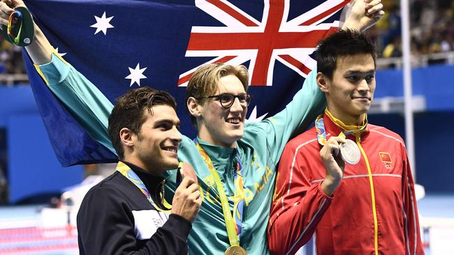 Australia's Mack Horton (C) holds the Australian flag as he pose next to Sun Yang (R).
