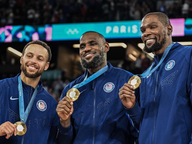 TOPSHOT - Gold medallists (From L) USA's #04 Stephen Curry, USA's #06 LeBron James and USA's #07 Kevin Durant pose after the men's Gold Medal basketball match between France and USA during the Paris 2024 Olympic Games at the Bercy  Arena in Paris on August 10, 2024. (Photo by Damien MEYER / AFP)