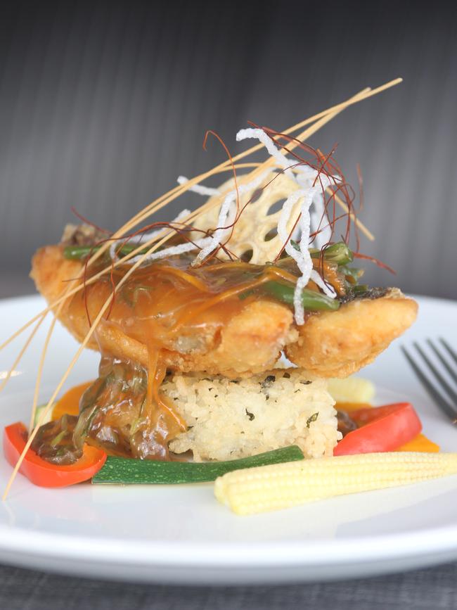 The restaurant’s Crisp Wild Barramundi Stack. It is layered on a rice triangle with seasonal vegetables.