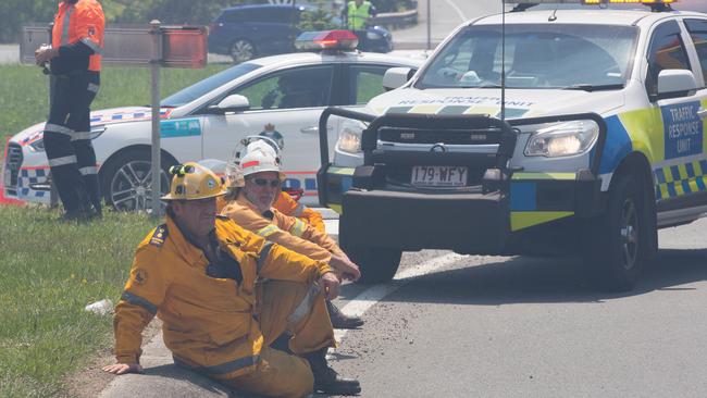 Firefighters take a break from working to contain a bushfire at the southern end of Peregian Beach on the border with Coolum Beach, Queensland, Wednesday, October 23, 2019. The fire started north of the Coolum High school and travelled north towards the beach. Picture: AAP Image/Rob Maccoll