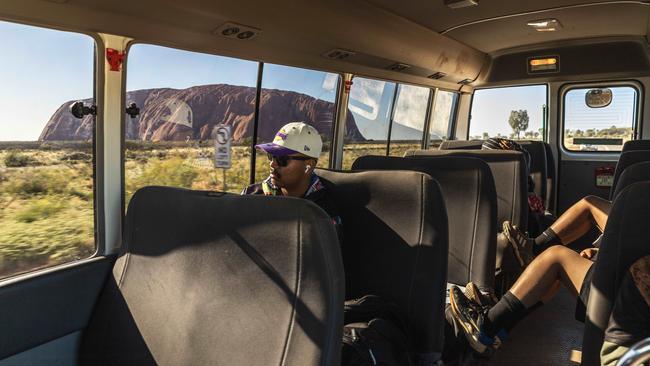 Staff members and students catch the school bus to Nyangatjatjara College in Yulara, at the foot of Uluru. Picture: Nico Liengme