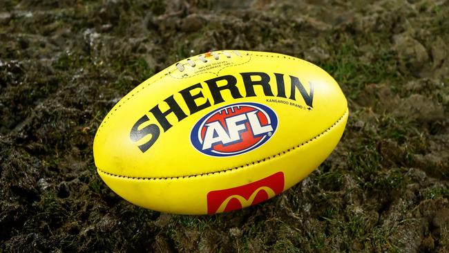 GEELONG, AUSTRALIA - JULY 20: The yellow Sherrin football is seen in mud during the 2024 AFL Round 19 match between the Geelong Cats and the Western Bulldogs at GMHBA Stadium on July 20, 2024 in Geelong, Australia. (Photo by Michael Willson/AFL Photos via Getty Images)