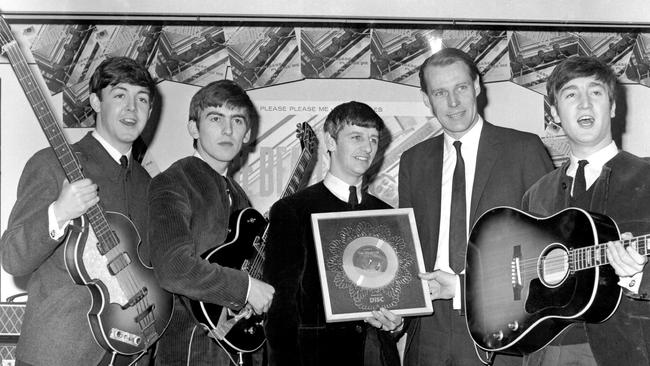 Paul McCartney, George Harrison, Ringo Starr, George Martin and John Lennon together, circa 1964.