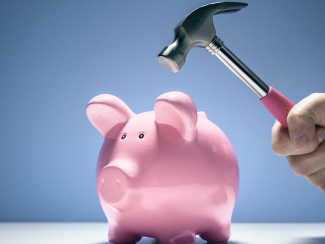 Pink piggy bank money box and hand with hammer about to hit and smash to get at savings, saving withdrawing superannuation generic