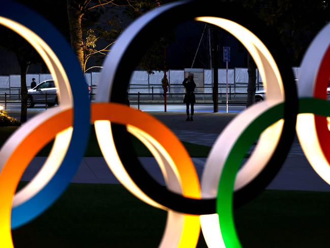 A woman takes pictures of Olympic Rings in Tokyo on January 8, 2021, as Tokyo Olympics organisers insisted that the coronavirus-postponed Games will still go ahead despite Japan declaring a state of emergency less than 200 days before the opening ceremony. (Photo by Behrouz MEHRI / AFP)