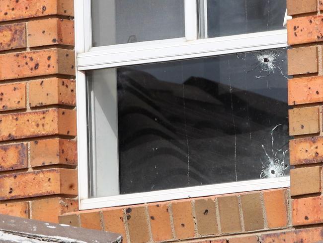 Bullet holes seen in a top floor window. Picture: David Crosling