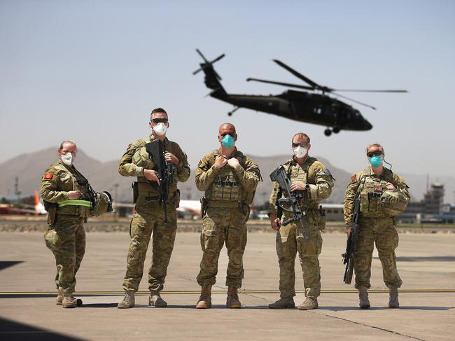 KABUL, AFGHANISTAN - NewsWire Photos - JUNE 15, 2021 - EXCLUSIVE:Australia has withdrawn its last remaining troops from Afghanistan ahead of the 11 September deadline.Australian troops prepare to board a RAAF C17 aircraft at the Hamid Karzai International Airport in Kabul, Afghanistan as a Black Hawk helicopter takes off behind them.This was the second last ADF flight o load equipment and depart Afghanistan for good.Picture: NCA NewsWire / Gary Ramage