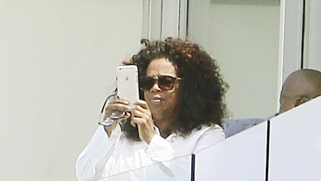 Oprah Winfrey on the balcony at Icebergs where it looked like she was getting a photo of the view before departing Bondi Beach during her Australian visit. Picture: John Appleyard