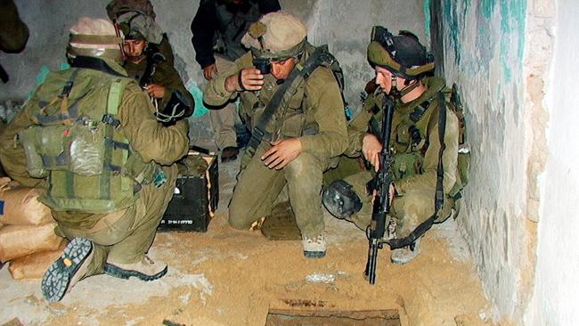 Israeli soldiers examine a hole in a house in the southern Gaza city of Rafah in 2003, where they found two 30m-deep tunnels used for smuggling weapons from Egypt.