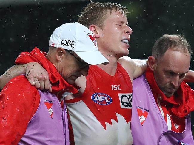 BRISBANE, AUSTRALIA - JULY 12: Isaac Heeney of the Swans is carried off injured during the round 6 AFL match between The Sydney Swans and the Richmond Tigers at The Gabba on July 12, 2020 in Brisbane, Australia. (Photo by Jono Searle/AFL Photos/via Getty Images)