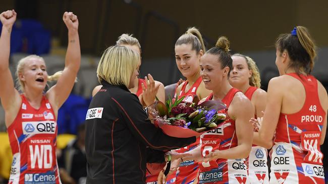 NSW Swifts head coach Briony Akle presents Paige Hadley with flowers to celebrate her 100th game.