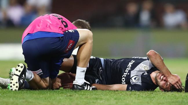 Melbourne Victory midfielder Terry Antonis lies in pain on the SCG turf after injuring his knee. Picture: AAP 