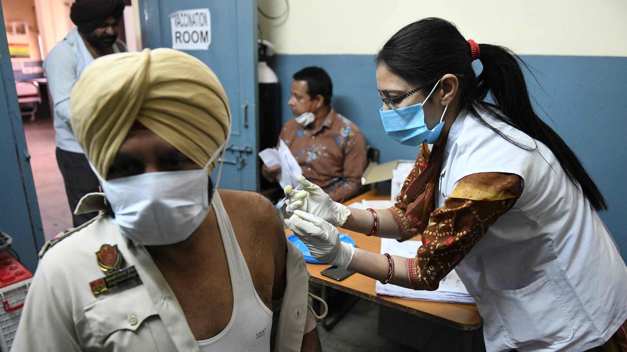 A medical worker inoculates a police officer. Picture: Narinder Nanu/AFP