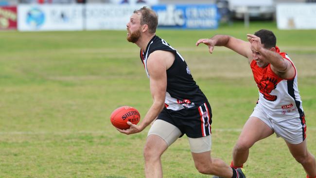 Christies Beach player Jacob Crate is about to be tackled by Flagstaff Hill’s Ben Rossi. Picture: AAP/Brenton Edwards