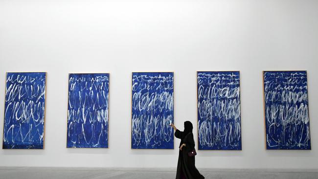 A visitor takes a photo of a piece of a series of nine panels titled "Untitled I-IX" by American artist Cy Twombly at the Louvre Abu Dhabi Museum on November 11, 2017 during its official opening to the public on Saadiyat island in the Emirati capital.  More than a decade in the making, the Louvre Abu Dhabi opened its doors bringing the famed name to the Arab world for the first time. / AFP PHOTO / GIUSEPPE CACACE / RESTRICTED TO EDITORIAL USE - MANDATORY MENTION OF THE ARTIST UPON PUBLICATION - TO ILLUSTRATE THE EVENT AS SPECIFIED IN THE CAPTION