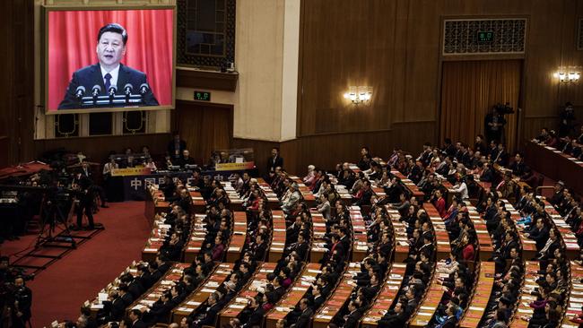 Delegates listen to a speech by China's President Xi Jinping as he is seen on a large screen at the National People's Congress. Picture: Getty