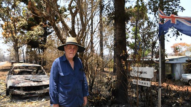 Mount Rae Rd resident Norm Timms lost property to the Cobraball fire but amazingly his house survived. In the background is a car that was burnt out by the fire.