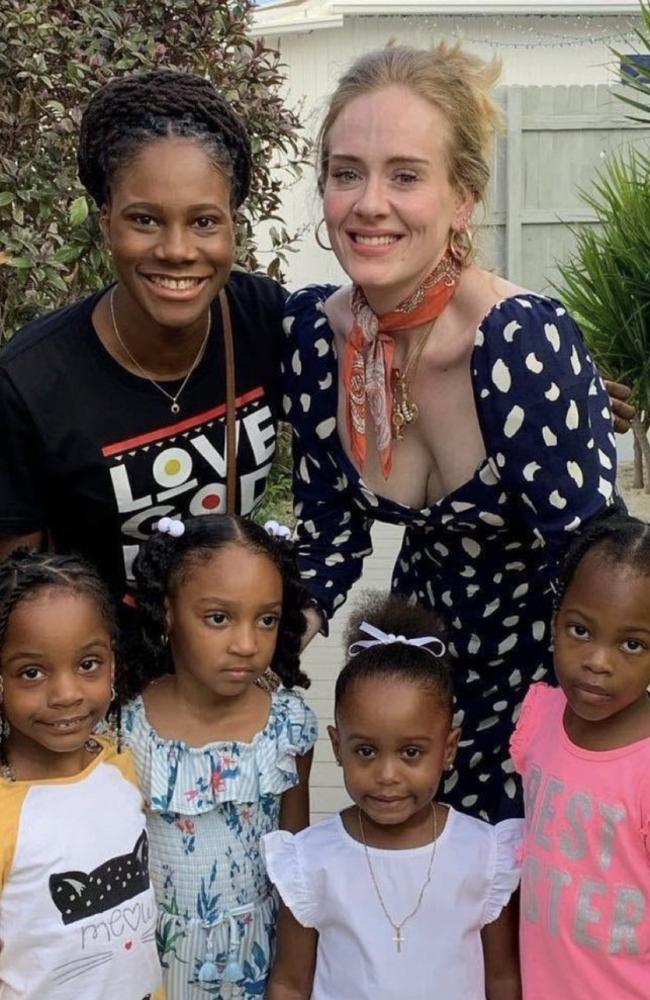 Adele poses with some fans.