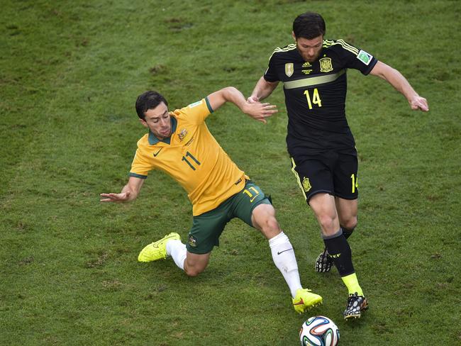 Tommy Oar (left) battles for the ball with Spain’s Xabi Alonso at the 2014 World Cup. Picture: AAP / Lukas Coch