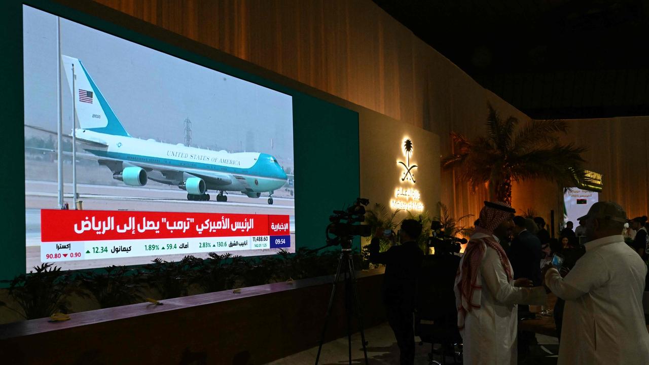 People watch a live coverage at the Ministry of Media as the plane carrying President Trump lands in Riyadh, Saudi Arabia. Picture: AFP