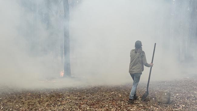 Temagog women fighting a fire with hand tools. Picture: Chris Knight.