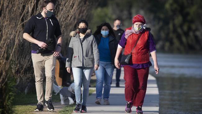 People exercise around Melbourne’s Albert Park lake in their mandatory mask on Saturday. . Picture: NCA NewsWire / Sarah Matray