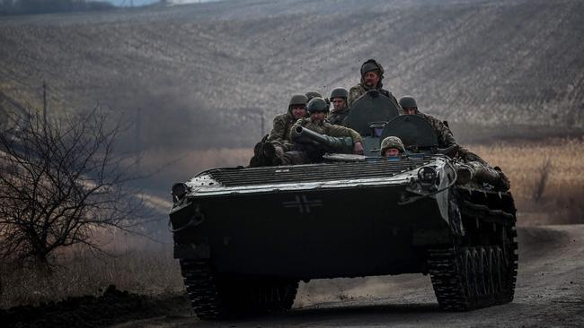 Ukrainian servicemen ride atop a tank near the frontline city of Bakhmut on Friday. Picture: AFP