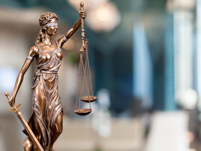 A bronze statue of the Lady Of Justice  composited into a blur background of a law firm. istock image