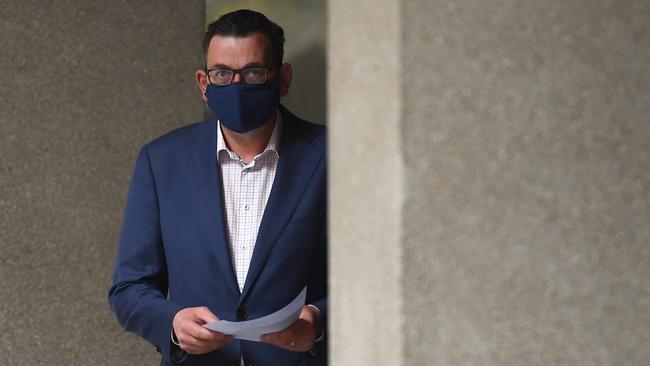 Victorian Premier Daniel Andrews enters his press conference wearing a face mask on Monday.