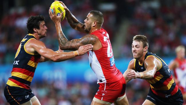 Kyle Hartigan, left, and Daniel Talia tackle Sydney's Lance Franklin on Friday night. Hartigan left the game soon after with a hamstring injury. Picture: Phil Hillyard