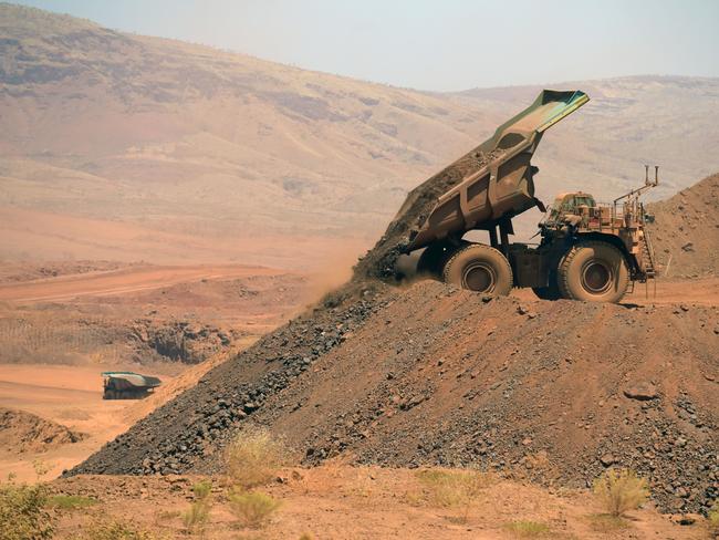 An autonomous haul truck dumps a load of rock in the mine pit at Rio Tinto Group's Gudai-Darri iron ore mine in the Pilbara region of Western Australia, Australia, on Thursday, Oct. 19, 2023. Rio Tinto is preparing for trials of battery-powered locomotives in Australia, where it uses giant autonomous trains — the world’s largest and longest robots — to transport iron ore across the vast Outback. Photographer: Carla Gottgens/Bloomberg