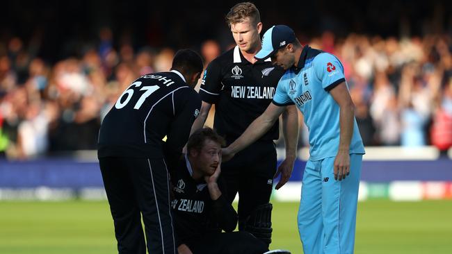 Martin Guptill is consoled by teammates and Chris Woakes. Picture: Getty