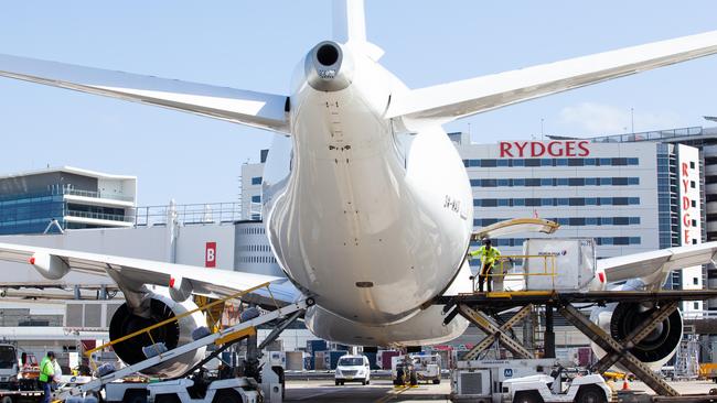 Workers load a jet at Sydney International Airport. Picture: AAP Image/Jordan Shields.