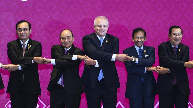 Australian Prime Minister Scott Morrison (centre) and Prime Minister of Vietnam Nguyen Xuan Phuc hold hands with other Asian leaders during a family picture at the 14th East Asia Summit in Bangkok, Thailand, last November.