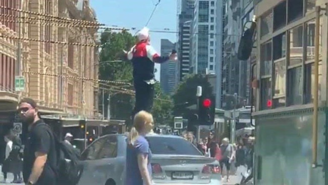 Blayze Pemberton-Burden was allegedly captured ranting and waving his arms at people while standing on the roof of a silver car on the corner of Flinders and Elizabeth streets