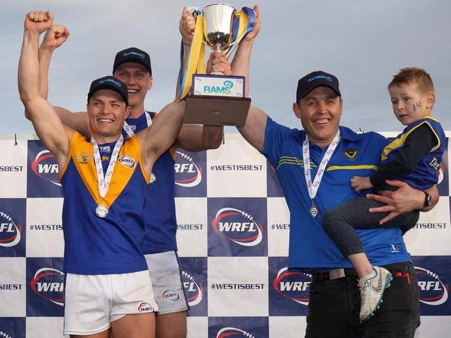 Jake McKenzie, captain Jack Purton-Smith and coach Marc Bullen hoist the silverware after Deer Park defeated Altona in the WRFL Division 1 grand final. Picture: Local Legends Photography