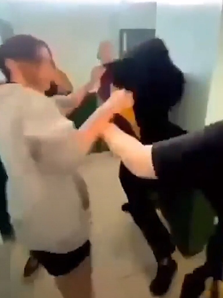 The girl in the lighter top starts the fight and is encouraged by friends to keep going.