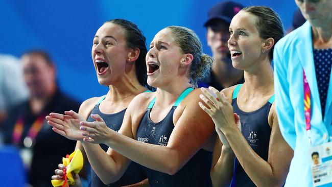 Brianna Throssell, Leah Neale and Emma McKeon, of Australia, cheer on teammate Ariarne Titmus during the women’s 4x200m freestyle relay final. Picture: Clive Rose/Getty Images