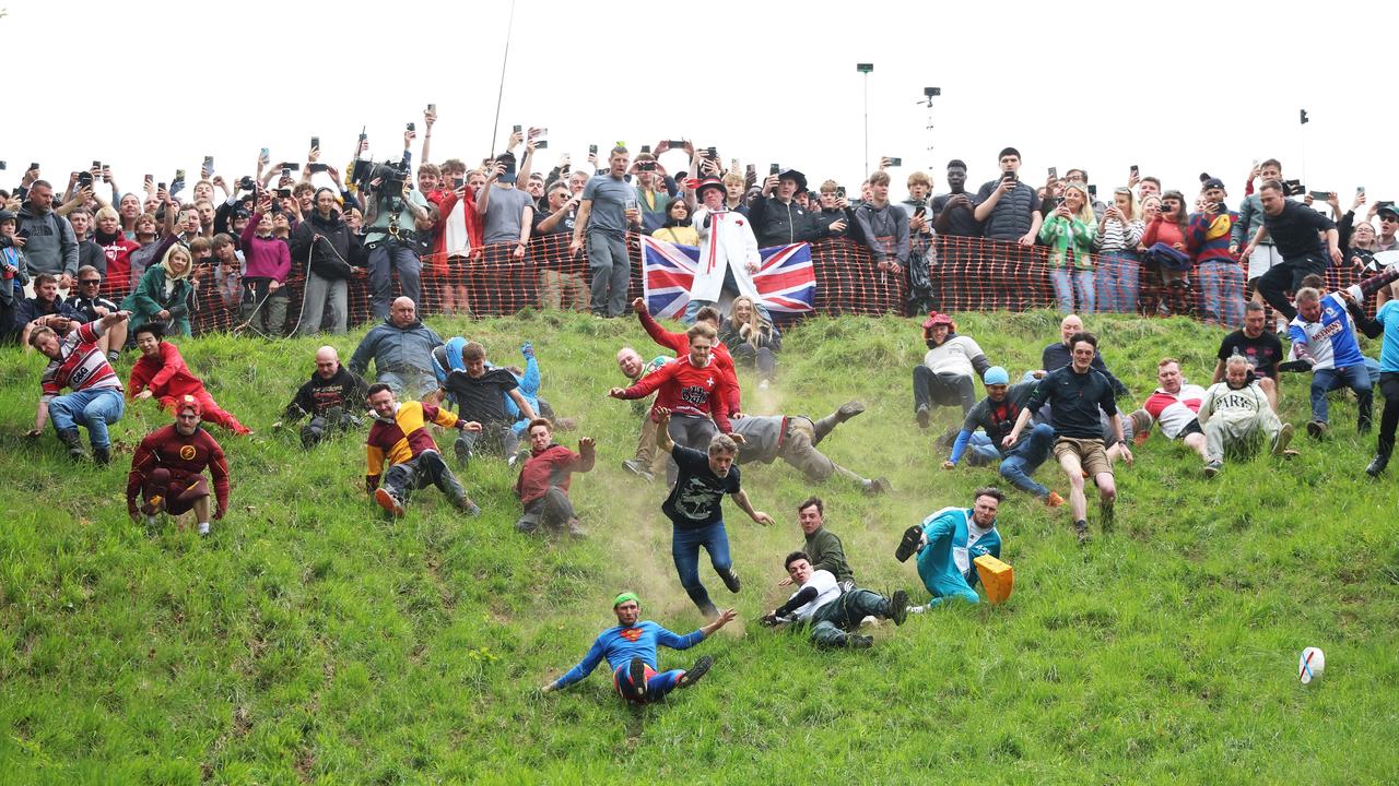 Contestants in the mens Downhill Race chase the cheese down the hill on May 26, 2025 in Brockworth, England. Picture: Cameron Smith/Getty Images