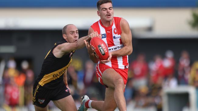 Glenelg’s Alex Martini gets his fist to the ball to spoil North Adelaide’s Noah Casalini at the Bay on Saturday. Picture: Cory Sutton.