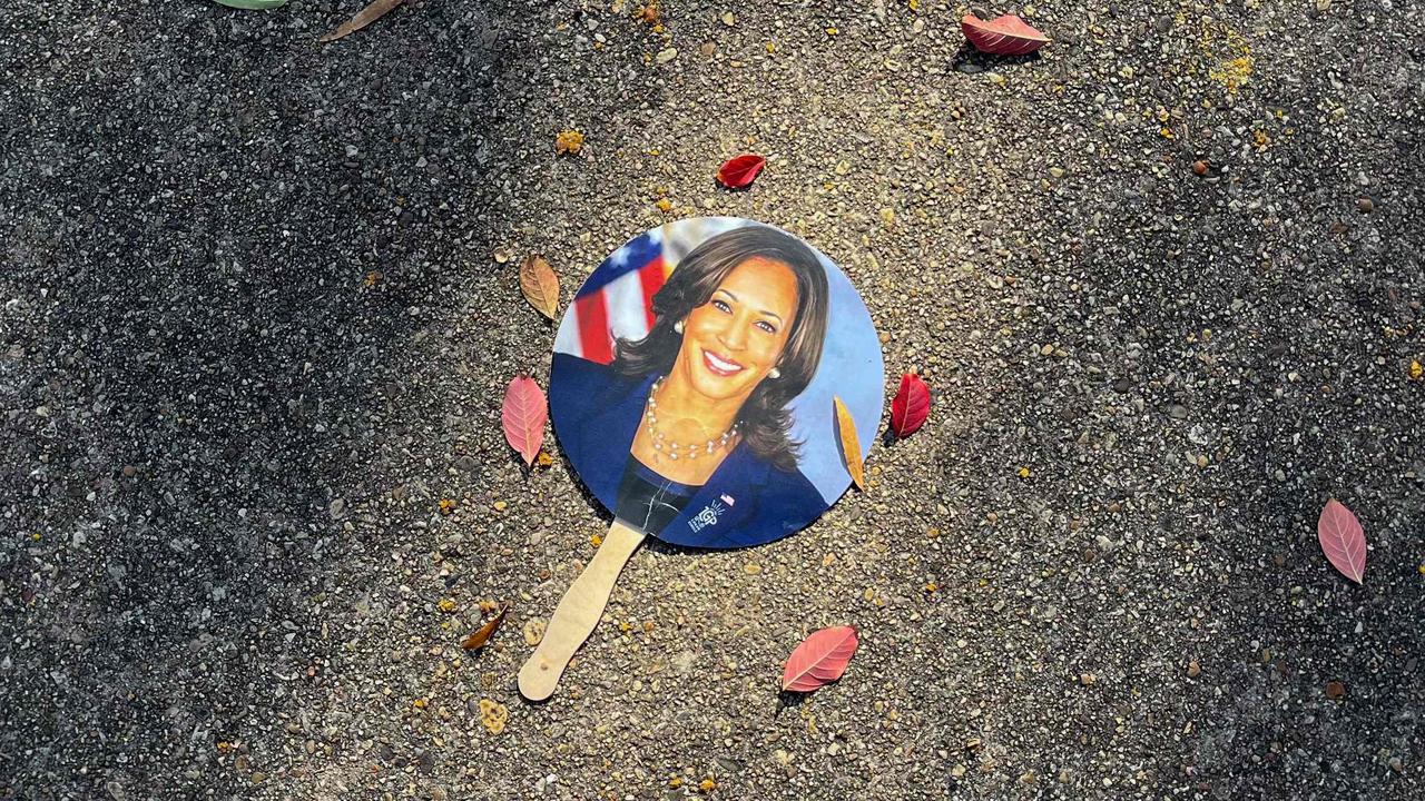 A hand fan depicting US Vice President Kamala Harris lays on a sidewalk in Washington, DC, on November 6, 2024. (Photo by Bastien INZAURRALDE / AFP)