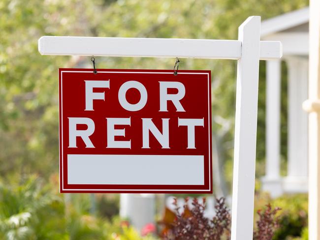 Red For Rent Real Estate Sign in Front House.