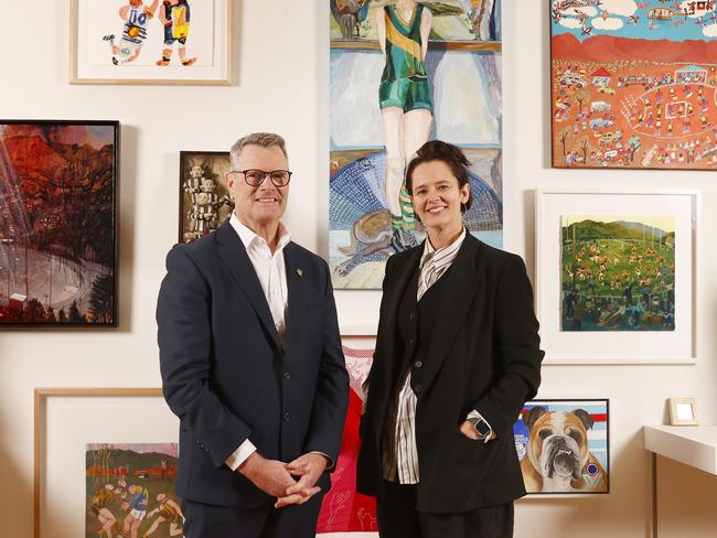 Grant O'Brien chair Tasmania Football Club with Emma Bett co-director of Bett Gallery and work from the exhibition.  The Footy Show exhibition at Bett Gallery in Hobart.  Picture: Nikki Davis-Jones