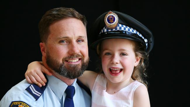 Snr Constable Andrew Mitchell pictured with his daughter Gracie received an award for jumping into Wyong River after a man drove a car in. Picture: Sue Graham